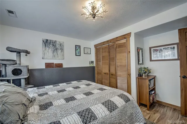 a bedroom with a large bed and a chandelier