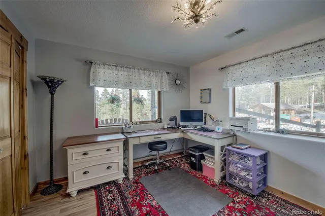 a view of a workspace with furniture and a window