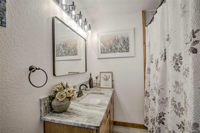 a bathroom with a granite countertop sink and a mirror
