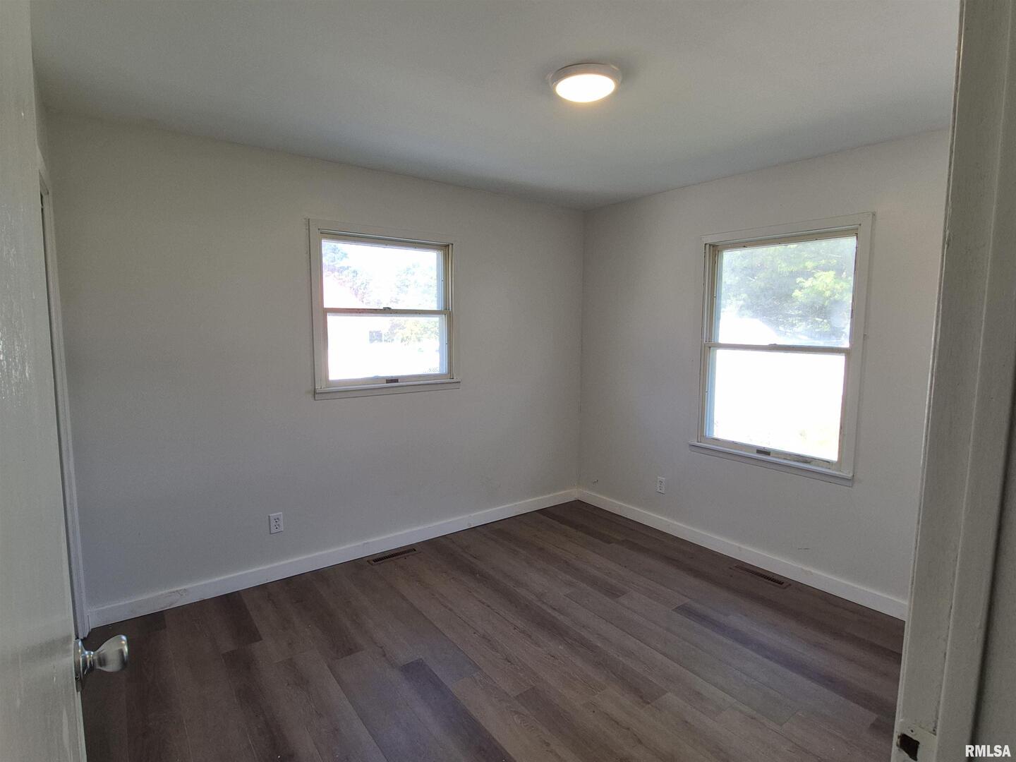 802 Dillard Street Eldorado, IL 62930 - Photo 14 of 24 an empty room with wooden floor and windows