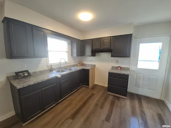 a kitchen with a sink a window and cabinets