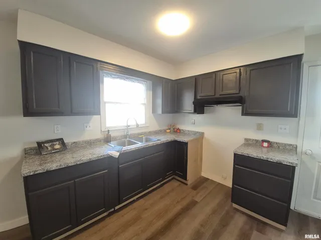a kitchen with granite countertop a sink stainless steel appliances and cabinets