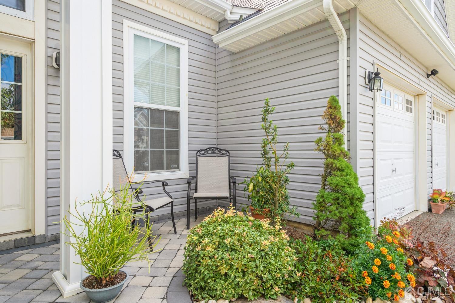 114 Riviera Drive Monroe Township, NJ 08831 - Photo 2 of 40 a view of a back yard of the house with a chairs and table in a patio
