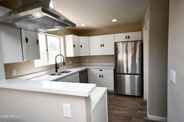 a kitchen with refrigerator and cabinets