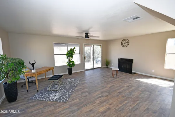 a view of an empty room with window and wooden floor