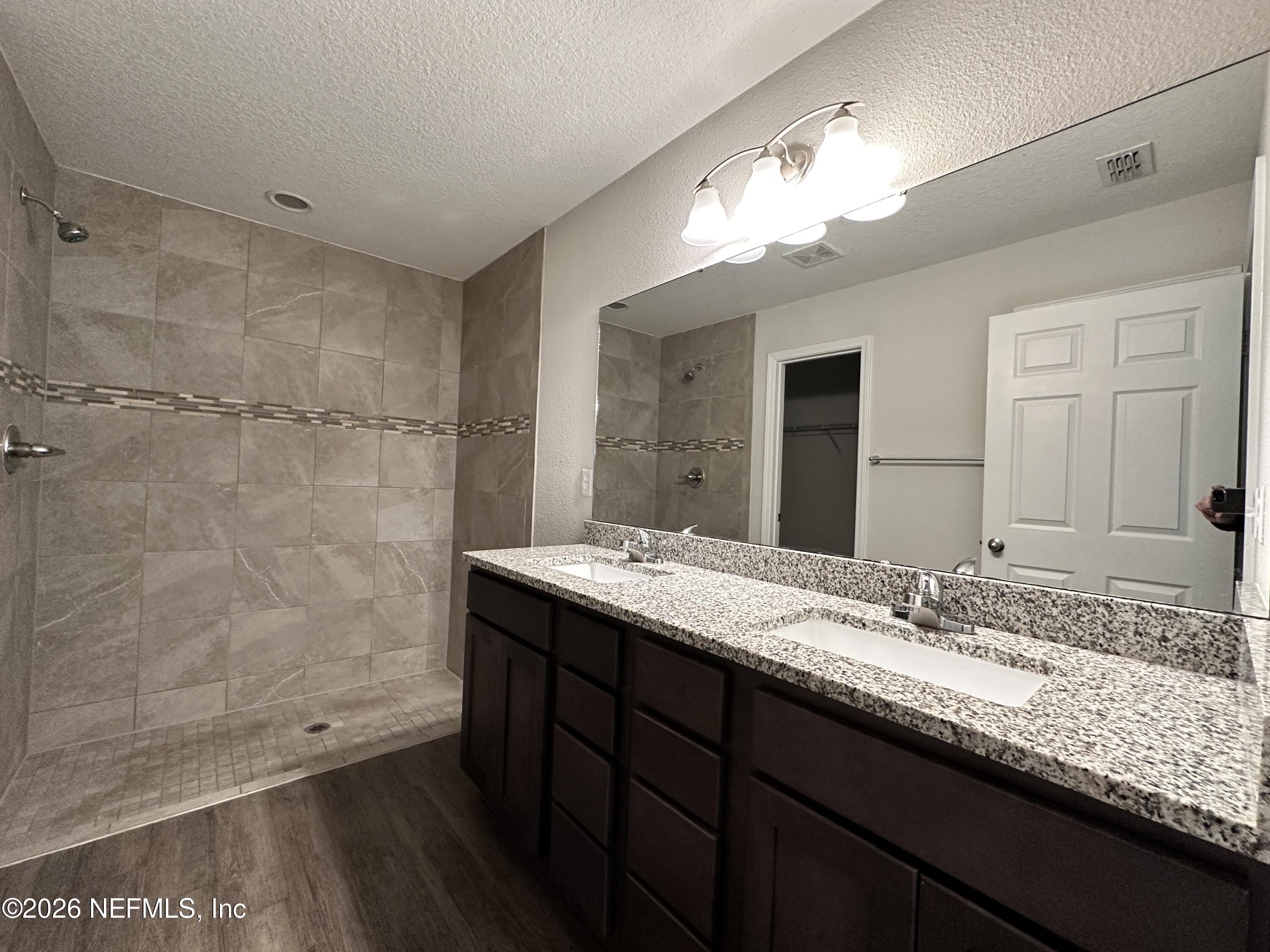3460 Belfort Road Jacksonville, FL 32216 - Photo 9 of 16 a bathroom with a sink double vanity and a mirror