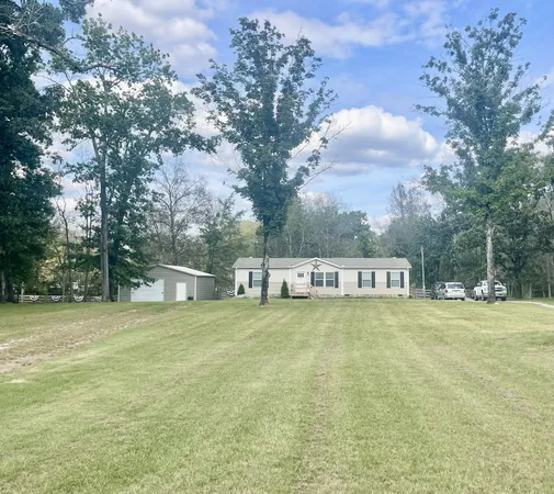 a house that has a big yard with large trees