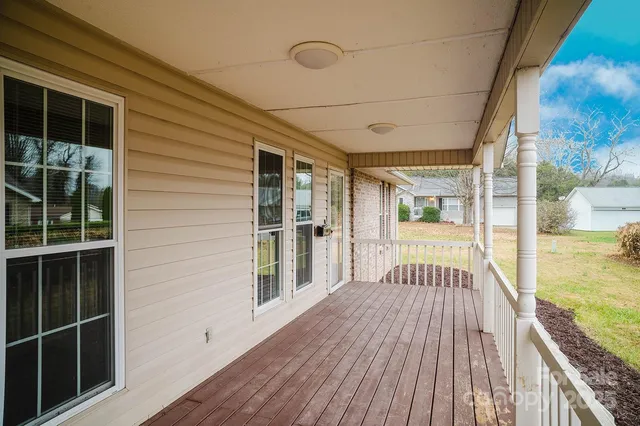 a view of a balcony with wooden floor and fence