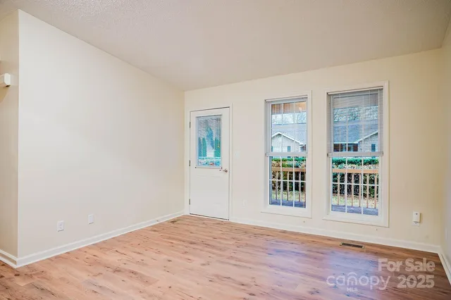a view of a big room with wooden floor and windows