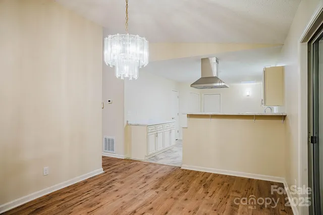 a view of empty room with wooden floor and ceiling fan