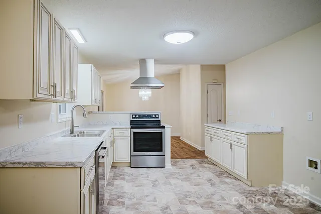 a kitchen with granite countertop a sink stove and refrigerator