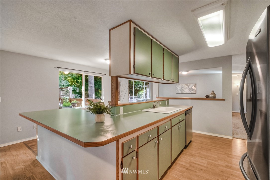 13708 Southeast 141st Street Renton, WA 98059 - Photo 13 of 19 a kitchen with stainless steel appliances granite countertop a sink a microwave and island