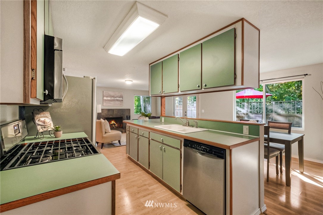 13708 Southeast 141st Street Renton, WA 98059 - Photo 14 of 19 a kitchen with stainless steel appliances granite countertop a sink stove and refrigerator