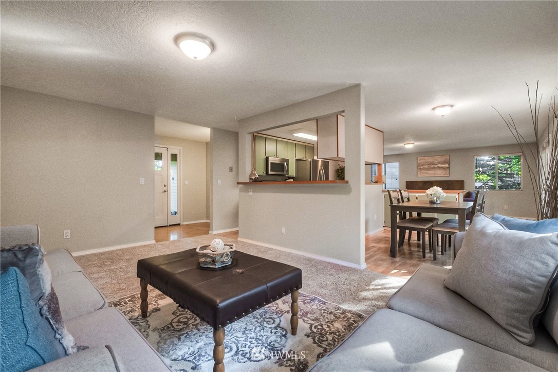 13708 Southeast 141st Street Renton, WA 98059 - Photo 6 of 19 a living room with furniture a table and kitchen view