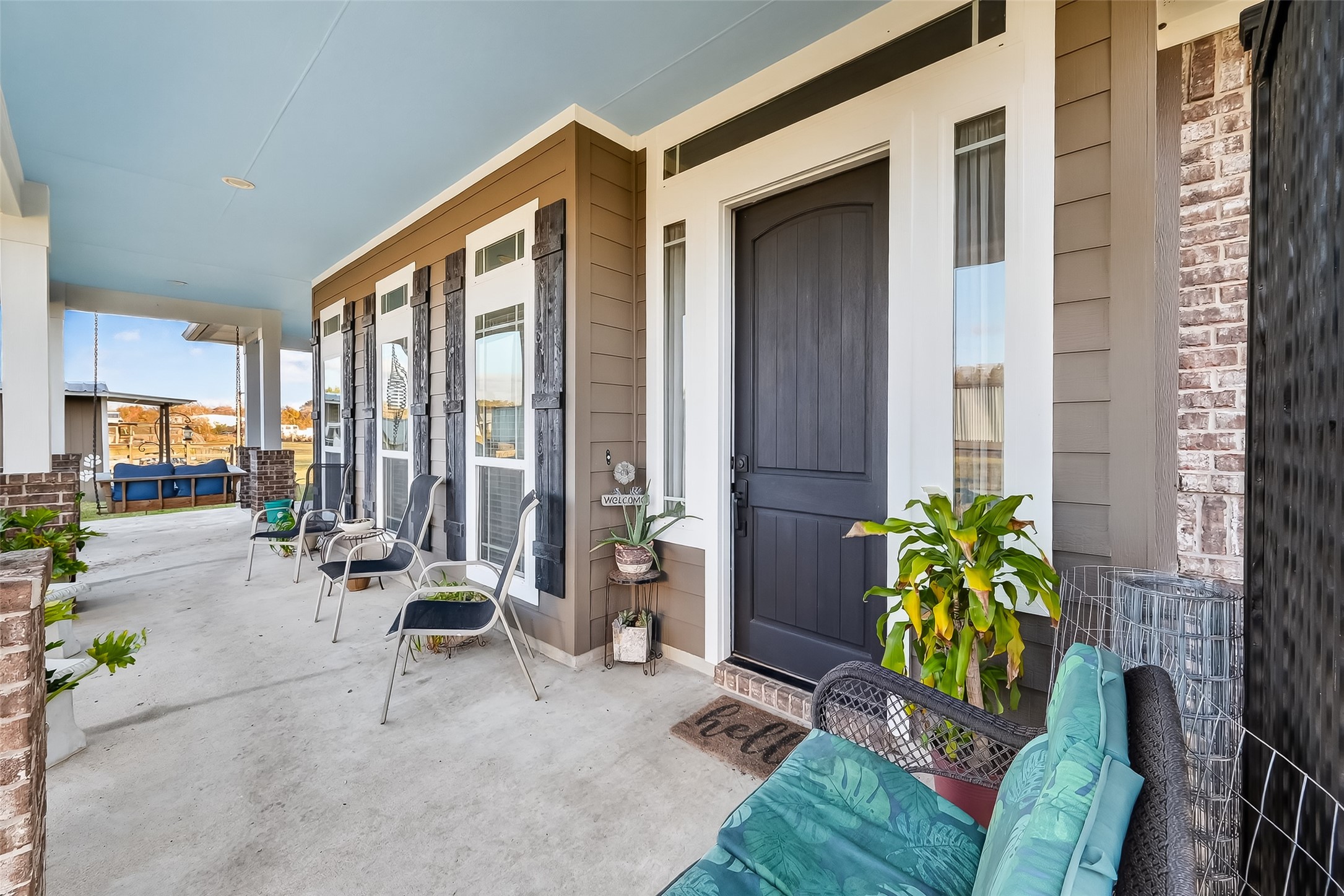912 County Road 340 Angleton, TX 77515 - Photo 7 of 50 This welcoming front porch features a covered area. The elegant entrance door is framed by large windows, offering a bright and inviting atmosphere.