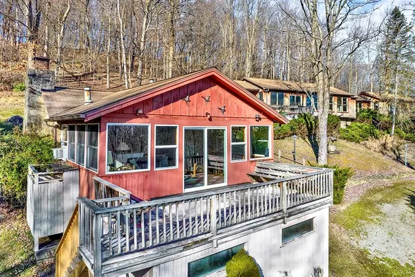 a view of a house with a deck and a yard