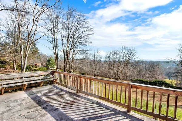 a view of a roof deck with wooden fence and floor