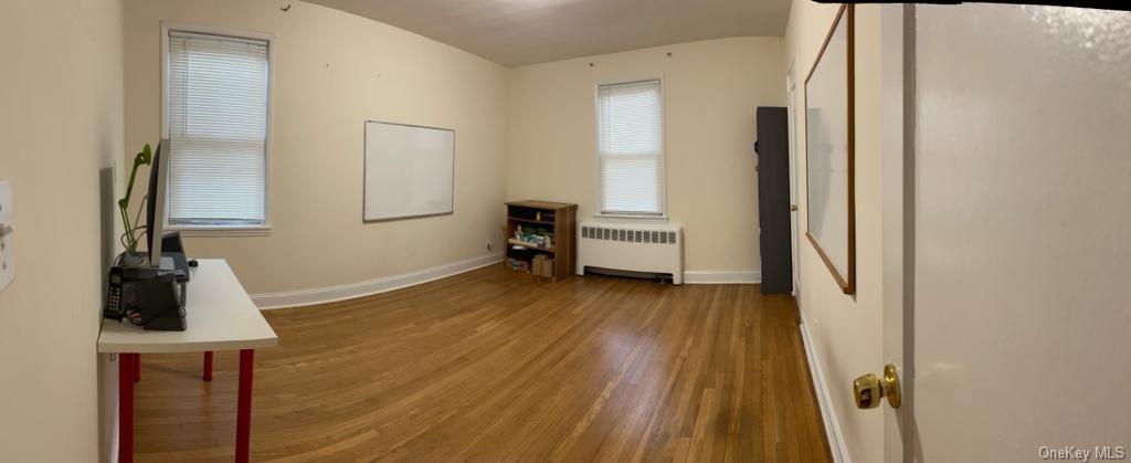 a view of a bedroom with wooden floor and furniture