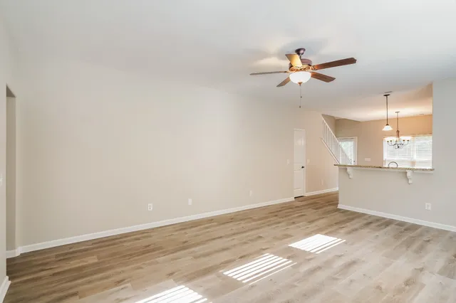 a view of a kitchen with wooden floor and a ceiling fan