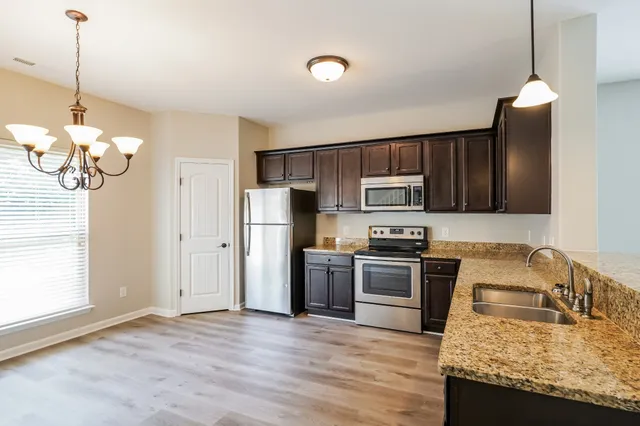 a kitchen with granite countertop stainless steel appliances and wooden cabinets