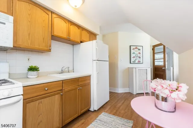 a kitchen with stainless steel appliances granite countertop a sink a microwave cabinets and wooden floor