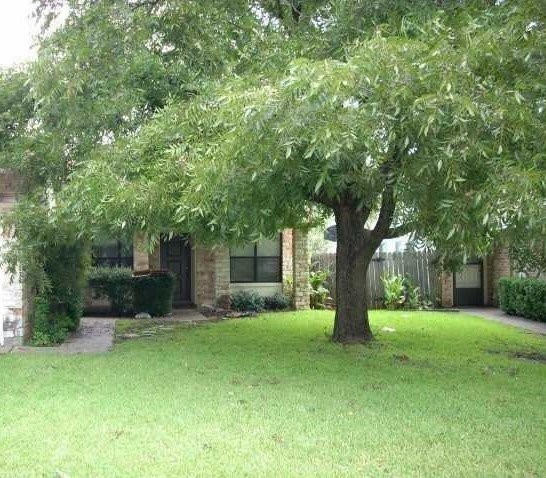 a view of a house with backyard and a tree