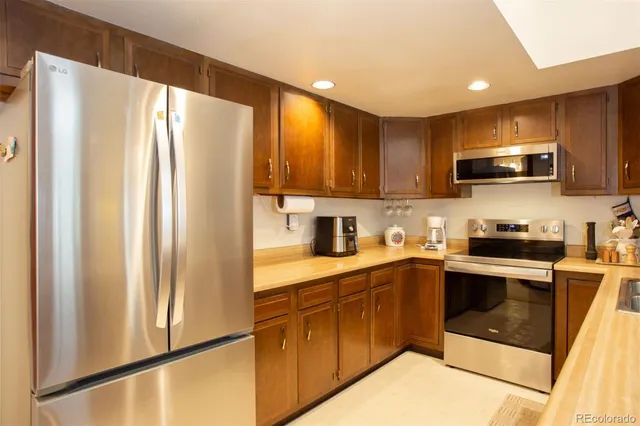 a kitchen with stainless steel appliances granite countertop a refrigerator sink and microwave