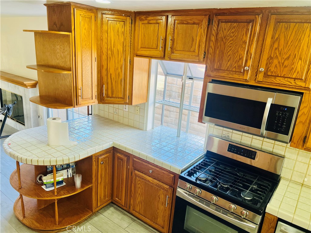 7363 Bothwell Road Reseda, CA 91335 - Photo 16 of 28 a kitchen with wooden cabinets and a stove top oven