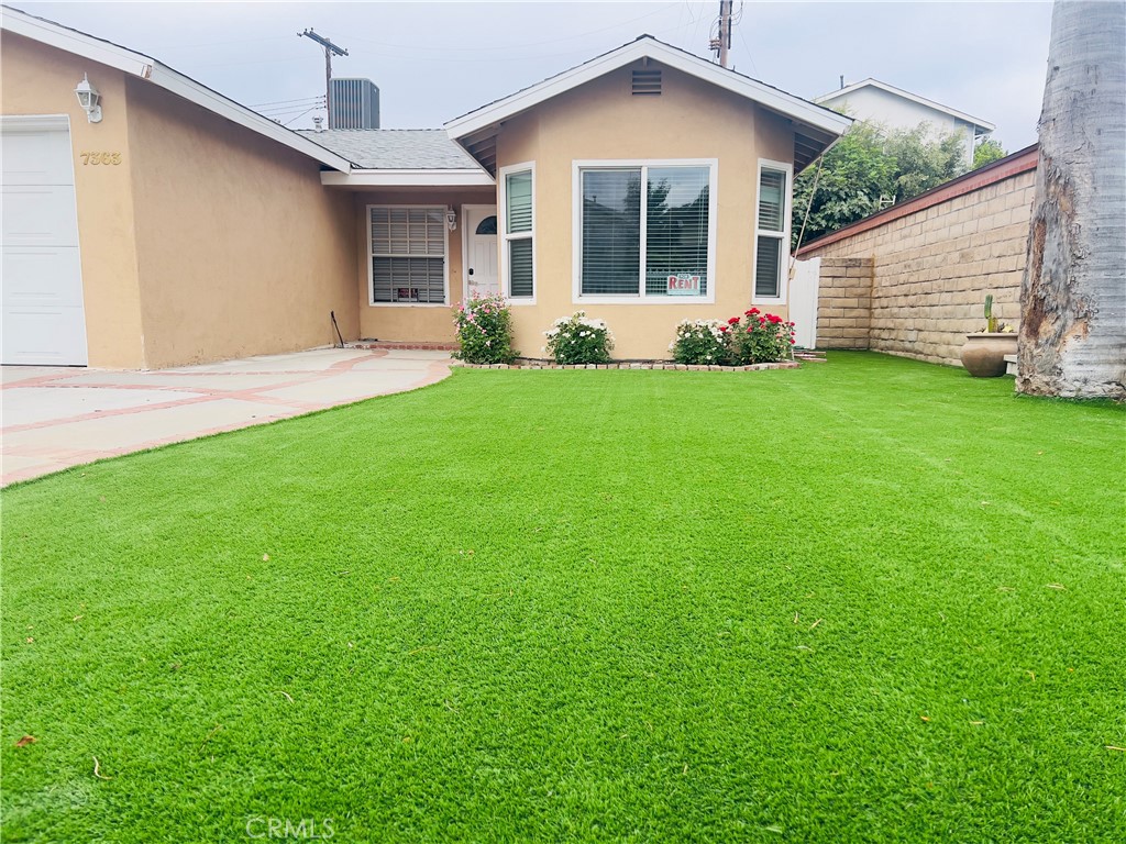 7363 Bothwell Road Reseda, CA 91335 - Photo 2 of 28 a front view of a house with a yard and garage