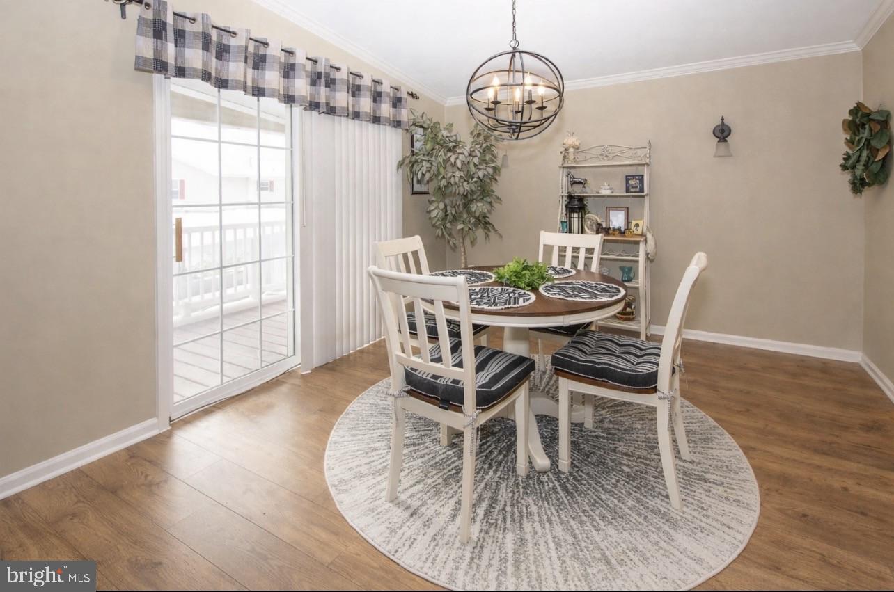 66 Random Road Douglassville, PA 19518 - Photo 7 of 27 a dining room with wooden floor a chandelier a glass table and chairs