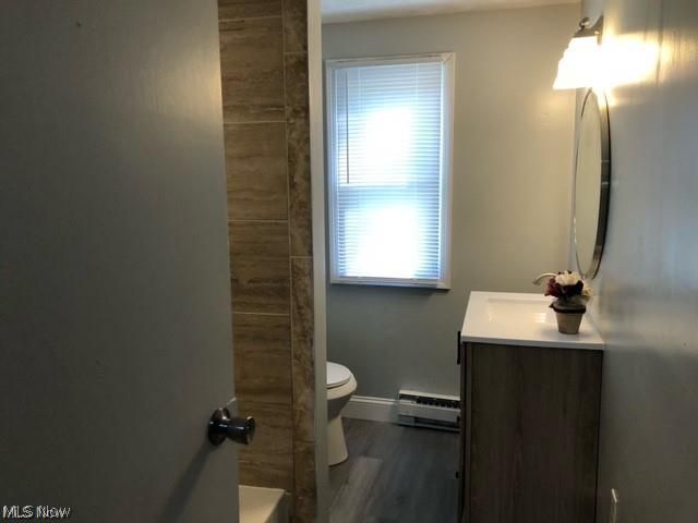 2752 Copley Road Akron, OH 44321 - Photo 21 of 35 Full bathroom featuring vanity, baseboard heating, dark wood-style floors, a shower, and a bathtub