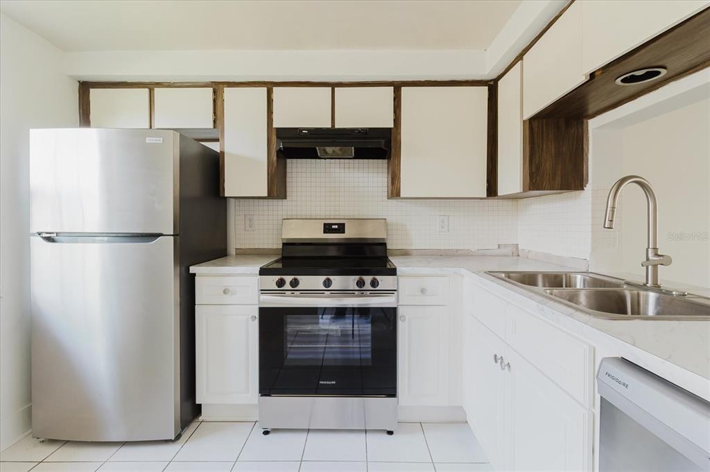 4235 Stratford Drive New Port Richey, FL 34652 - Photo 5 of 32 a kitchen with a refrigerator sink and cabinets