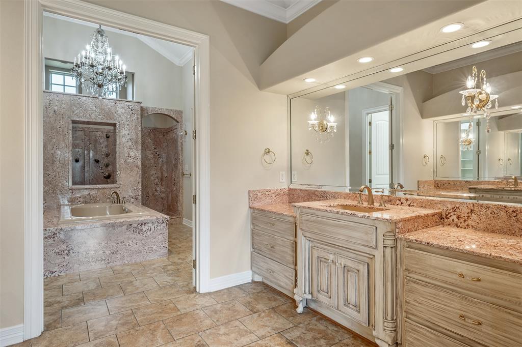 20389 County Road 178 Flint, TX 75762 - Photo 27 of 40 Double vanity with stone countertops and integrated sinks, extensive wall mirror, and ornate sconces