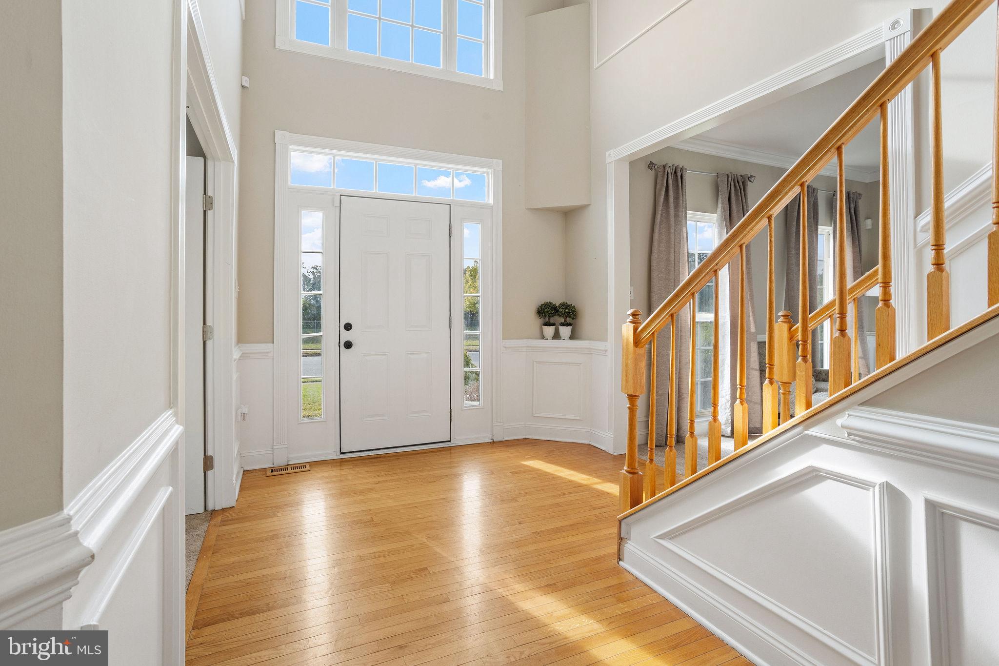 44 Red Fox Trail Sicklerville, NJ 08081 - Photo 4 of 49 a view of an entryway with wooden floor leading to a furnished livingroom and windows
