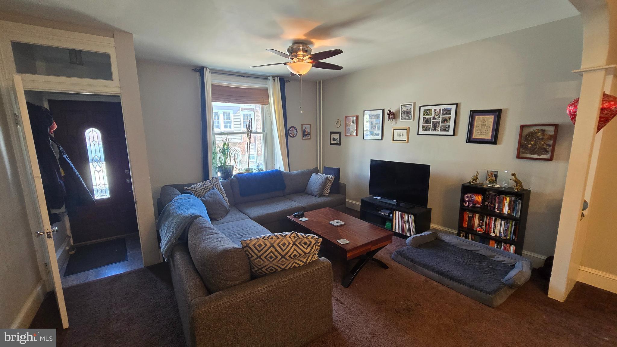 4606 Smick Street Philadelphia, PA 19127 - Photo 5 of 21 a living room with furniture a bookshelf and a flat screen tv