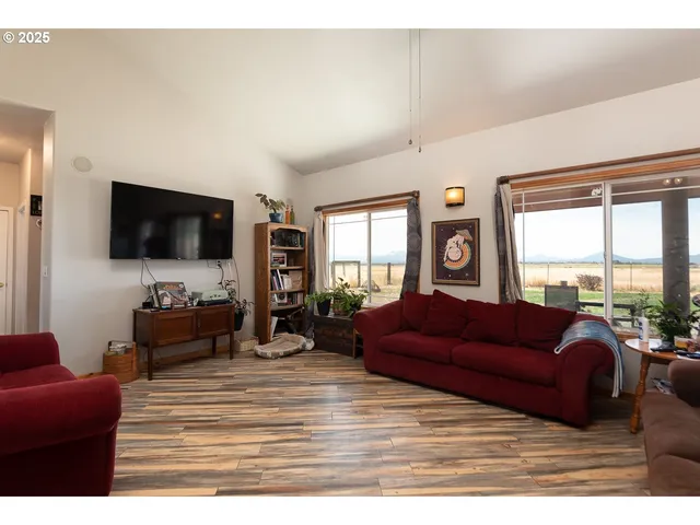 a large bedroom with a bed and a flat tv screen on dresser