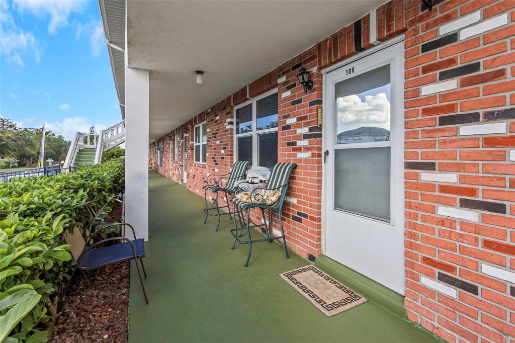 a picture of table and chairs with potted plants in front of door