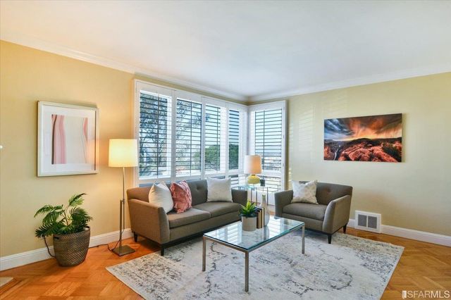 a living room with furniture and a potted plant