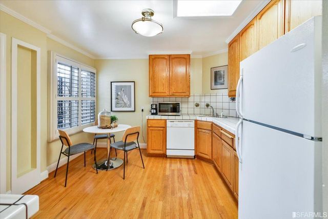 a kitchen with a sink appliances dining table and chairs