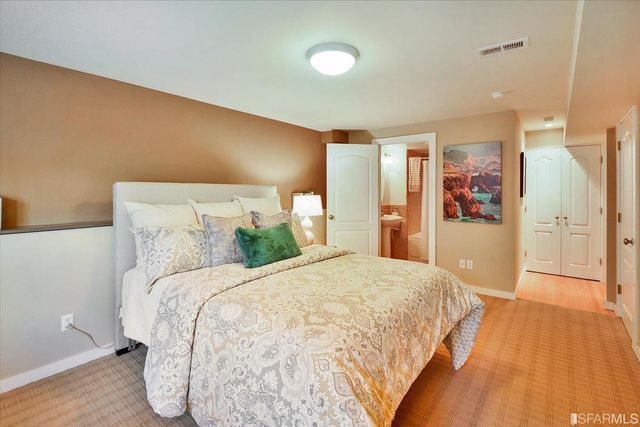 a bedroom with a bed and painting on the wall