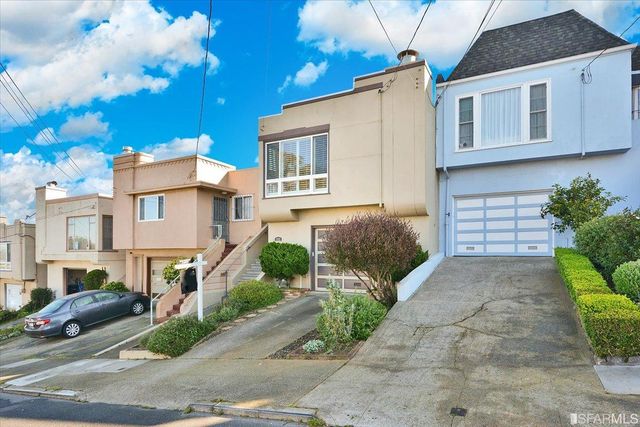 a front view of a house with a garden