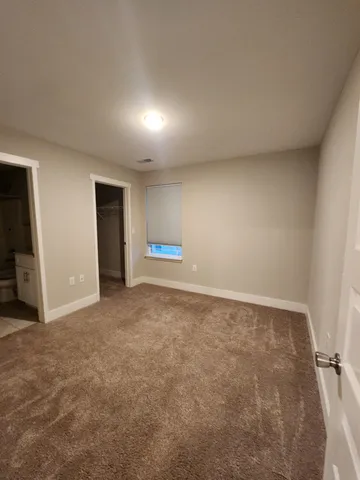 a view of an empty room and a bathroom