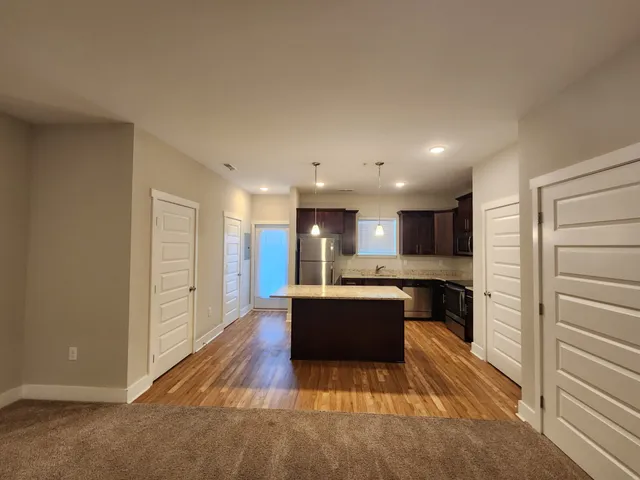 a large kitchen with kitchen island a sink stainless steel appliances and cabinets