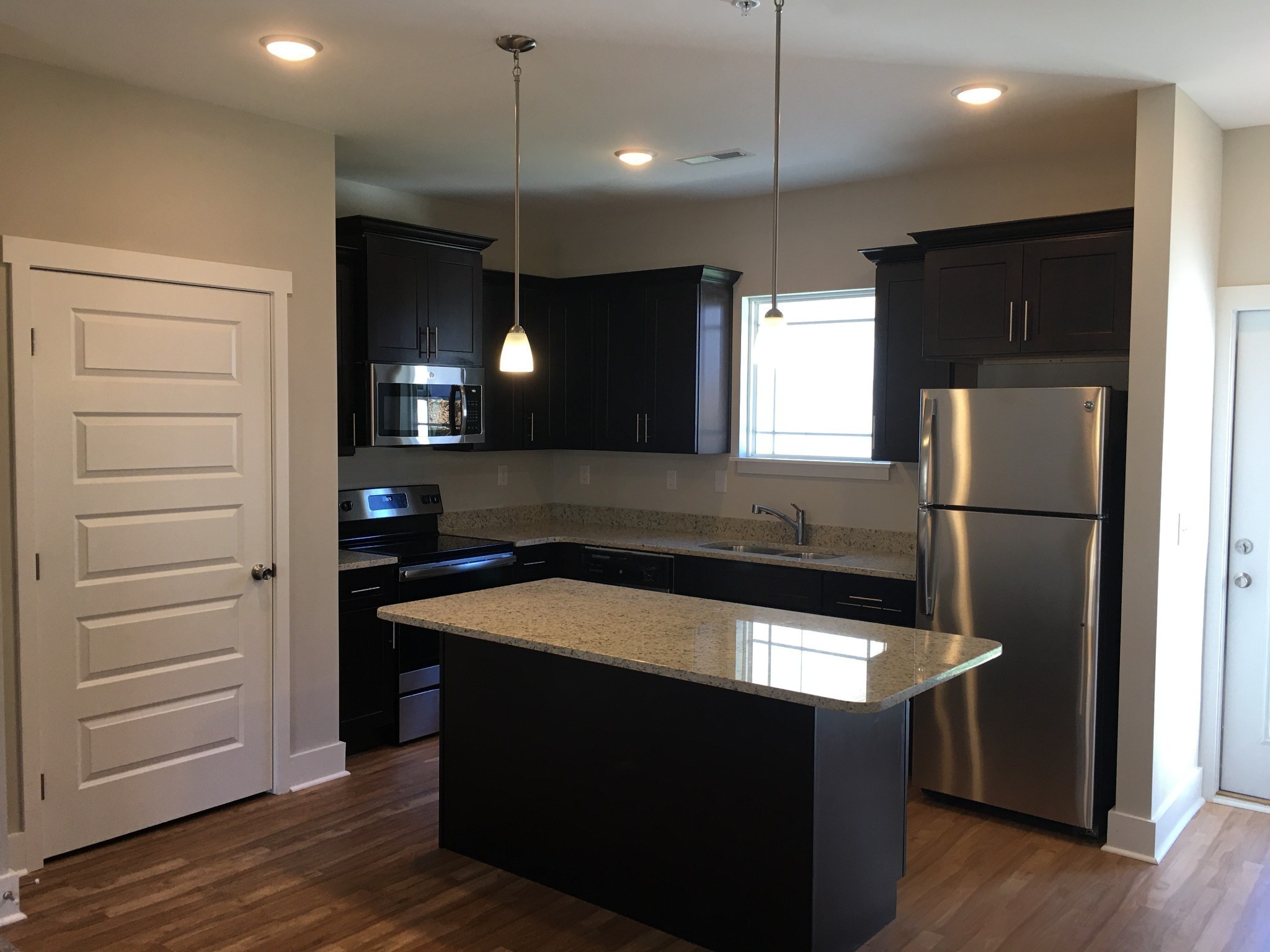 7002 Magnolia Crossings Spring Hill, TN 37174 - Photo 8 of 15 a kitchen with kitchen island a sink stainless steel appliances and cabinets
