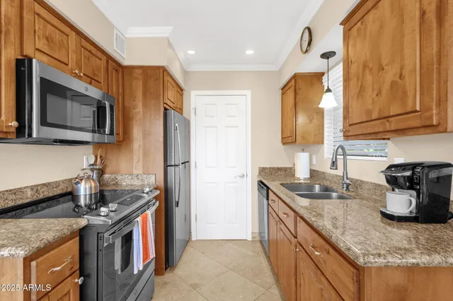 a kitchen with granite countertop sink cabinets and refrigerator