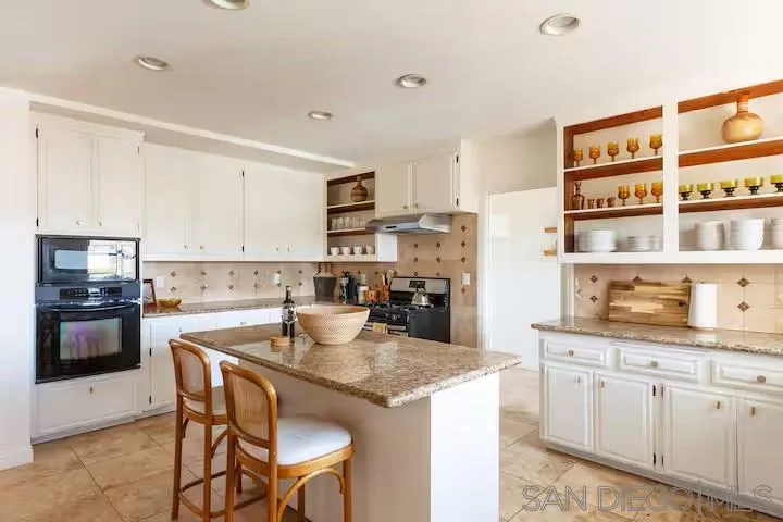 837 4th Street Encinitas, CA 92024 - Photo 15 of 41 a kitchen with kitchen island granite countertop a sink and cabinets