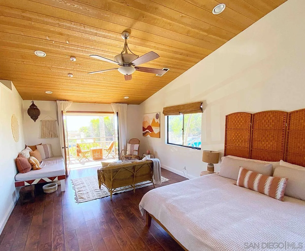 837 4th Street Encinitas, CA 92024 - Photo 25 of 41 a bedroom with a bed a couch and dresser with wooden floor