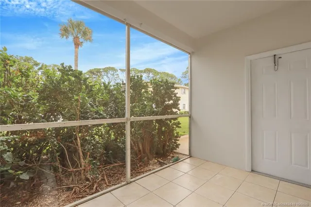 a view of a patio with couches chairs potted plants and a palm tree