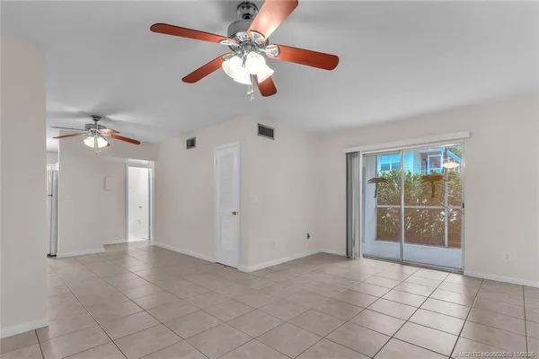 en empty room with windows and fan