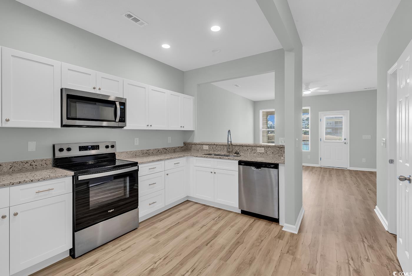 308 Kiskadee Loop, Unit E Conway, SC 29526 - Photo 9 of 36 Kitchen featuring stainless steel appliances, white cabinets, light stone counters, light wood-style flooring, and recessed lighting